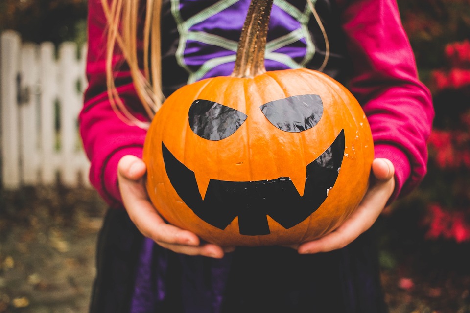 A face painted on a pumpkin. 