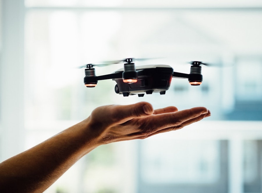 A drone hovering above a person's hands. 