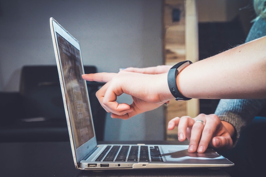 People pointing to a home tour on a laptop screen.